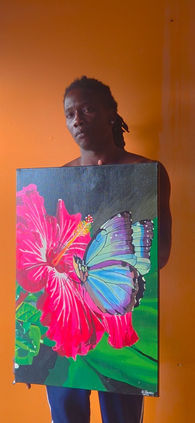 Grenadian artist Dain James holding a hibiscus and butterfly painting